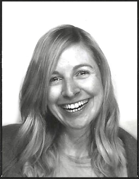 Shown is a portrait photo of Carmen Steins in black and white. She wears her hair loose and smiles.